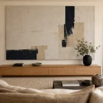 Décorer un grand mur salon : tableau XXL abstrait et miroir noir mat